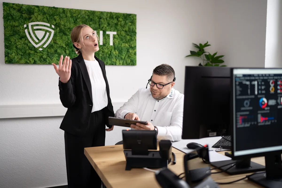 LNIT Kollegin erklärt Mitarbeiter Sicherheitsmaßnahmen am Tablet – Mitarbeiter-Sensibilisierung für IT-Sicherheit