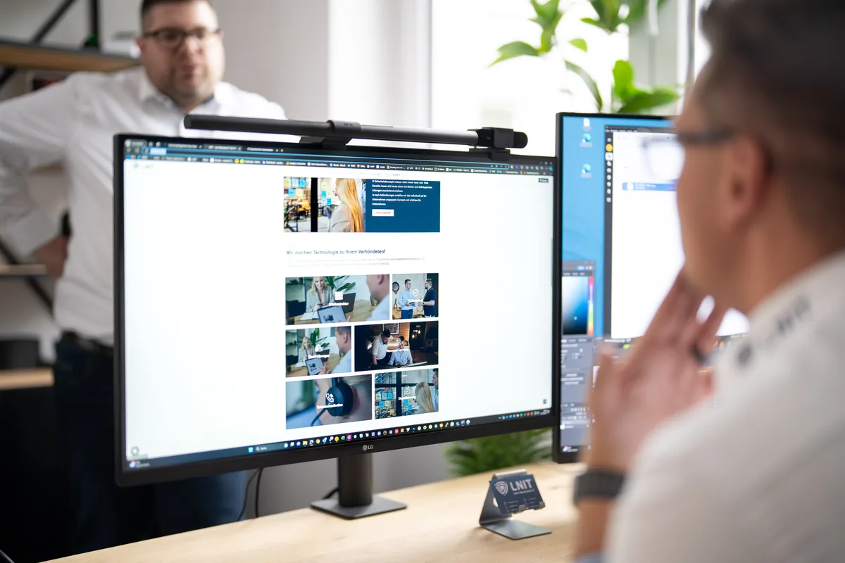 LNIT Team arbeitet gemeinsam am Dual-Monitor an Inhalten – SharePoint und Teams für effiziente Zusammenarbeit