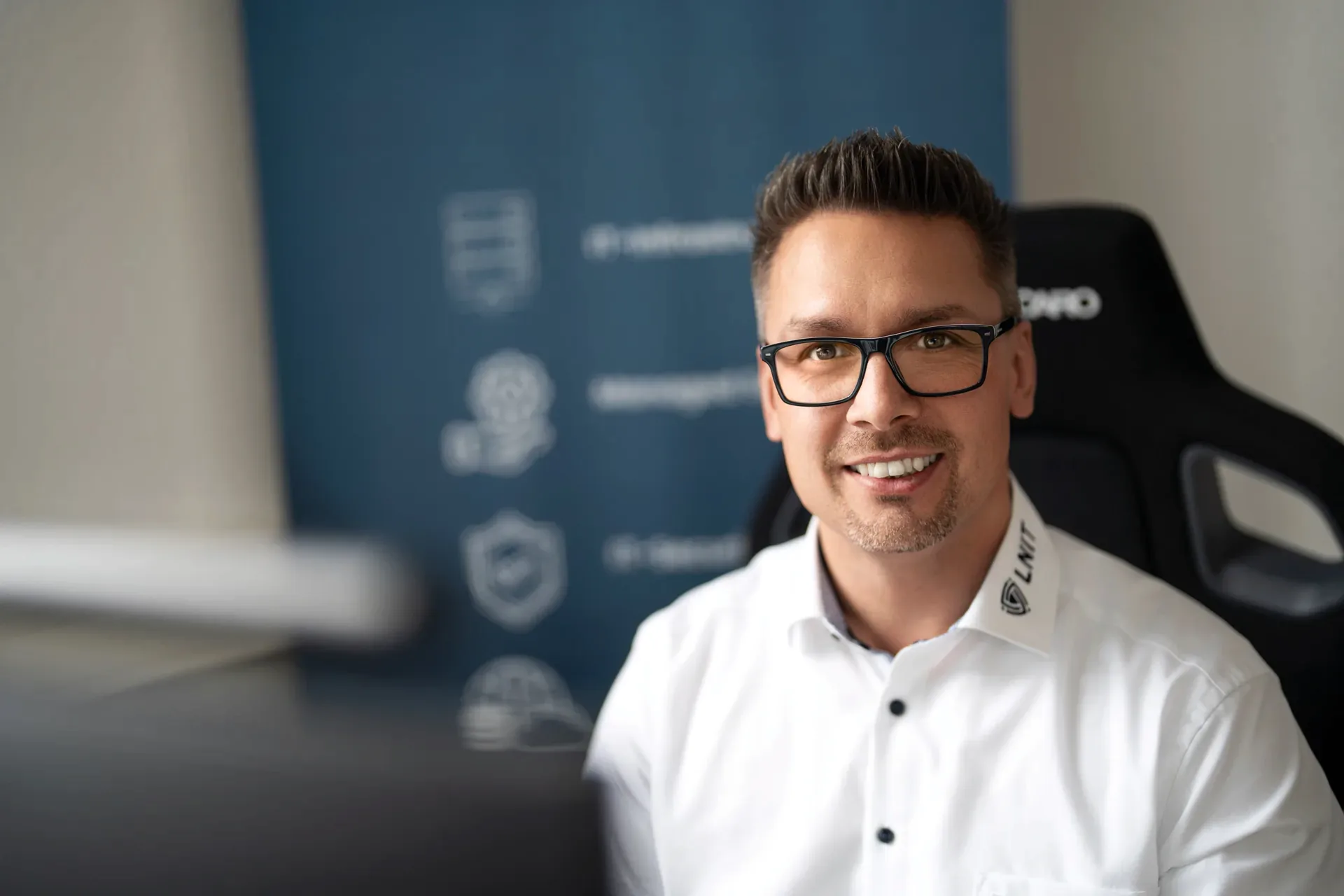 Lars Neumann lächelt im Büro in Diekholzen in die Kamera