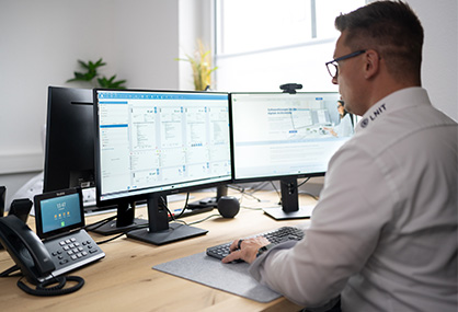 Mann arbeitet an zwei Monitoren im DMS System